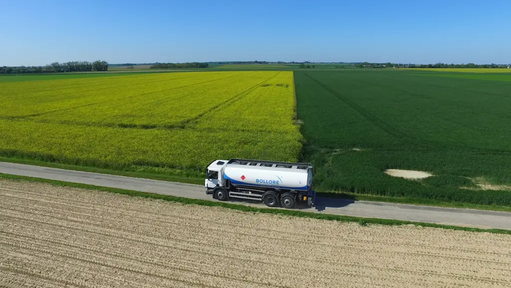 Camion-citerne Bolloré Energy circulant au bord de parcelles agricoles en zone rurale